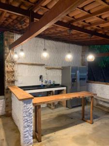 a kitchen with a wooden table and a refrigerator at Chalés da Gameleira in Areia +45 photos