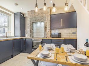 a kitchen with a wooden table with glasses on it at Spa Cottage in Bakewell