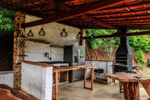 an outdoor kitchen with a stove and a grill at Chalés da Gameleira in Areia