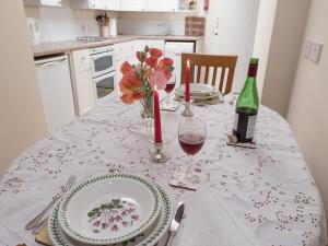 a table with a white table cloth with a bottle of wine at Little Trout in Middle Wallop