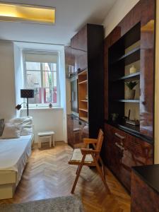 a bedroom with a bed and a chair and a window at Ritual Studio City Center in Ljubljana