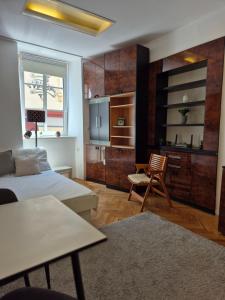 a bedroom with a bed and a table and a kitchen at Ritual Studio City Center in Ljubljana