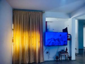 a curtain in a room with a table and a television at Cyrnos in Fez