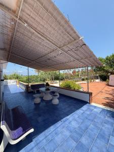 patio z dużym parasolem, stołami i krzesłami w obiekcie Magaggiari Beach House w mieście Cinisi