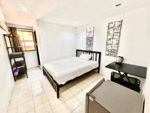a small bedroom with a bed and a desk at Patong Canal Villa R300 in Patong Beach +3 photos