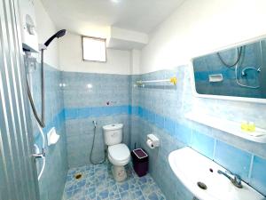 a blue tiled bathroom with a toilet and a sink at Patong Canal Villa R300 in Patong Beach