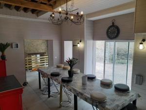 een eetkamer met een tafel met krukken en een klok bij king conde in Saint-Pierre-du-Regard