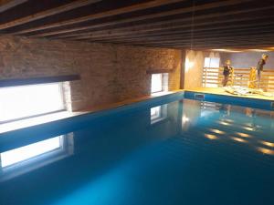 een zwembad in een gebouw met mensen op de achtergrond bij king conde in Saint-Pierre-du-Regard