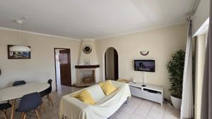 een woonkamer met een witte bank en een tafel bij Casa Vista Paraíso in Carvoeiro