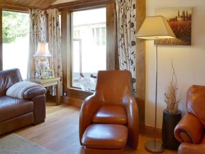 sala de estar con silla de cuero y lámpara en Beer Farm, en Stawley