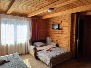 a bedroom with two beds in a wooden room at Садиба Гуцульський Двір in Vorokhta