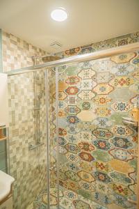 a bathroom with a shower with a tile wall at Къща за гости- Къпиновата къща  +13 photos