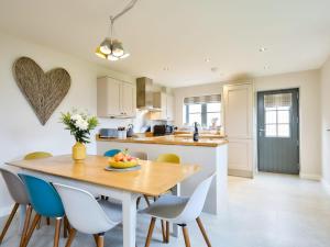 a kitchen and dining room with a wooden table and chairs at Seasalt in Mundesley