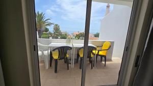 een tafel en stoelen op een balkon met uitzicht bij Casa Vista Paraíso in Carvoeiro