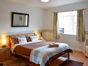 a bedroom with a large bed and a window at Honey Cottage in Auchnarrow +8 photos