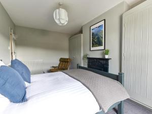 a bedroom with a white bed with blue pillows at Alt-Na-Craig in Rothbury +17 photos