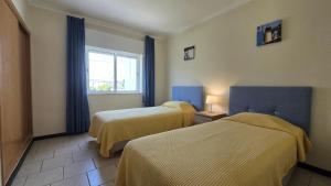 een hotelkamer met twee bedden en een raam bij Casa Vista Paraíso in Carvoeiro +24 foto's
