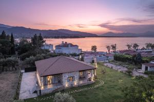 an aerial view of a house with a view of the water at PIETRA VILLA Akoli beach in Rodhodháfni