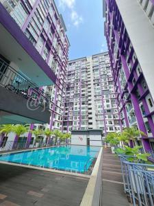 an apartment building with a swimming pool in front of it at Just Stay-Inn Guesthouse The Heights Residence Melaka in Ayer Keroh