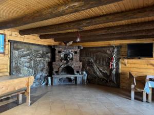 a living room with a fireplace and a tv at Садиба Гуцульський Двір in Vorokhta