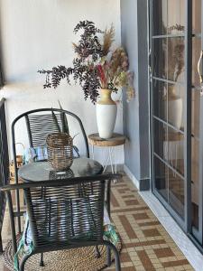a table and a chair and a vase with flowers at 84Rooms in Cayenne +18 photos