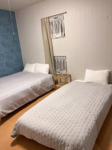 松山民泊 月的有两张床和一面镜子的房间