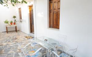 a dining room with a glass table and chairs at Ourania and Lena's House in Petra