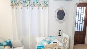 a white dining room with a table and a mirror at Ourania's and Lena's House in Petra +11 photos