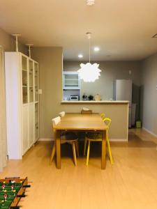 松山民泊 月的配有木桌椅的厨房和餐厅