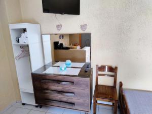eine Kommode in einem Zimmer mit einem Tisch und einem Stuhl in der Unterkunft Mpezas Studios in Igoumenitsa