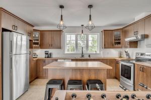 a kitchen with wooden cabinets and a white refrigerator at Initial - Jumeau 35 - MSA in Saint-Férréol-les-Neiges