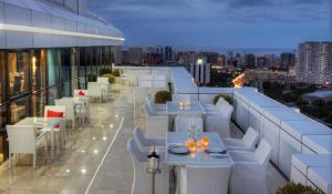 ein Restaurant mit weißen Tischen und Stühlen auf einem Gebäude in der Unterkunft VIP Apartment & Residence Baku in Baku
