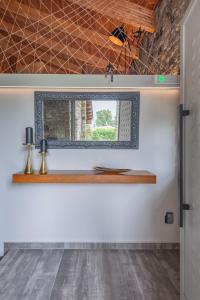 a mirror on a wall in a room at PIETRA VILLA Akoli beach in Rodhodháfni +60 photos