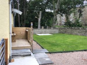a hot tub in a backyard with a lawn at Harland Cottage in Castletown