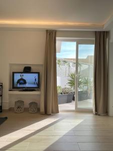 a living room with a television and a sliding glass door at That Place For U - Blue House in Costa da Caparica