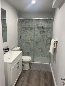 a bathroom with a shower and a toilet and a sink at The Place in Winnipeg