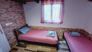 a small room with two beds and a window at Holiday house in Pula