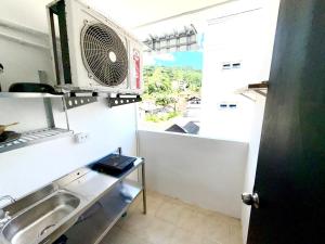 a small kitchen with a sink and a window at Patong Canal Villa R306 in Patong Beach