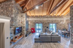a large living room with a stone wall at PIETRA VILLA Akoli beach in Rodhodháfni
