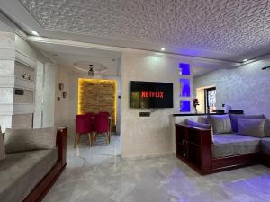 a living room with a couch and a tv on a wall at Duplex panoramique avec jardin in Chefchaouen