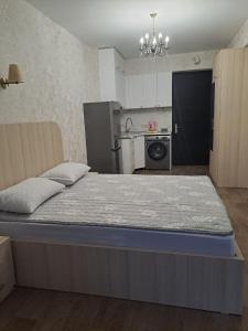 a large bed in a room with a kitchen at Mountains Inspiration Apartments in Likani