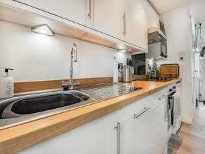 a kitchen with white cabinets and a sink at Uk41506 - Sunnybank in Hodgeston +10 photos