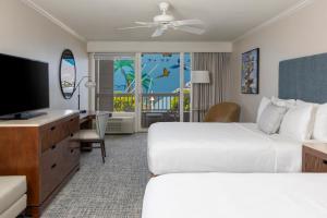 a hotel room with two beds and a flat screen tv at Opal Key Resort & Marina in Key West