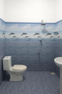 a bathroom with a toilet and birds on the wall at galle villa in Galle