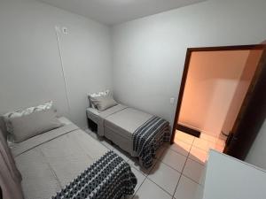 a small room with two beds and a mirror at Casa Alta Floresta in Monte Sião