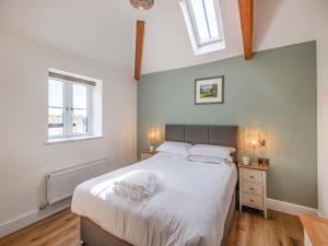 a bedroom with a large bed and two windows at Cor Tarw - Uk12743 in Acrefair +29 photos