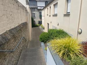 an alley with some plants and a building at La terrasse de l'Amirauté in Dinan