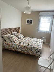 a bedroom with a bed with a comforter and a window at La terrasse de l'Amirauté in Dinan