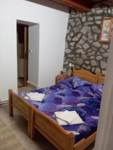 une chambre avec un lit avec une couette violette dans l'établissement Casa David Andrei Dubova, à Dubova