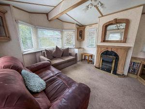 a living room with a couch and a fireplace at Great Caravan With Spacious Decking Southview Holiday Park, Skegness Ref 33035V in Skegness